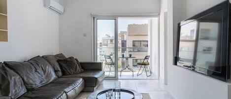 A modern living room with a leather sofa, a coffee table, and a TV.
