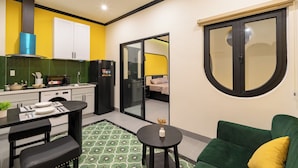 A compact living space with a kitchenette, a dining area, and a sofa. - NHA TRONG NGO 2 (Da Nang)