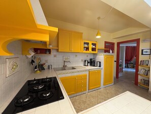 Uma cozinha com armários amarelos, fogão e pia.
