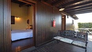 Uma cabana de madeira com uma cama, um banco e um extintor de incêndio.