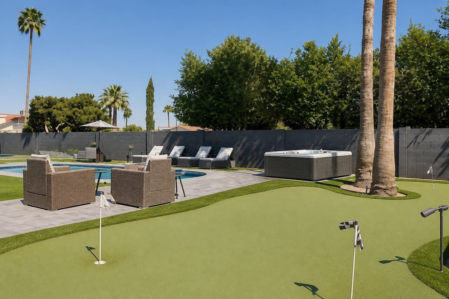 A backyard with a swimming pool, lounge chairs, a hot tub, and a putting green.