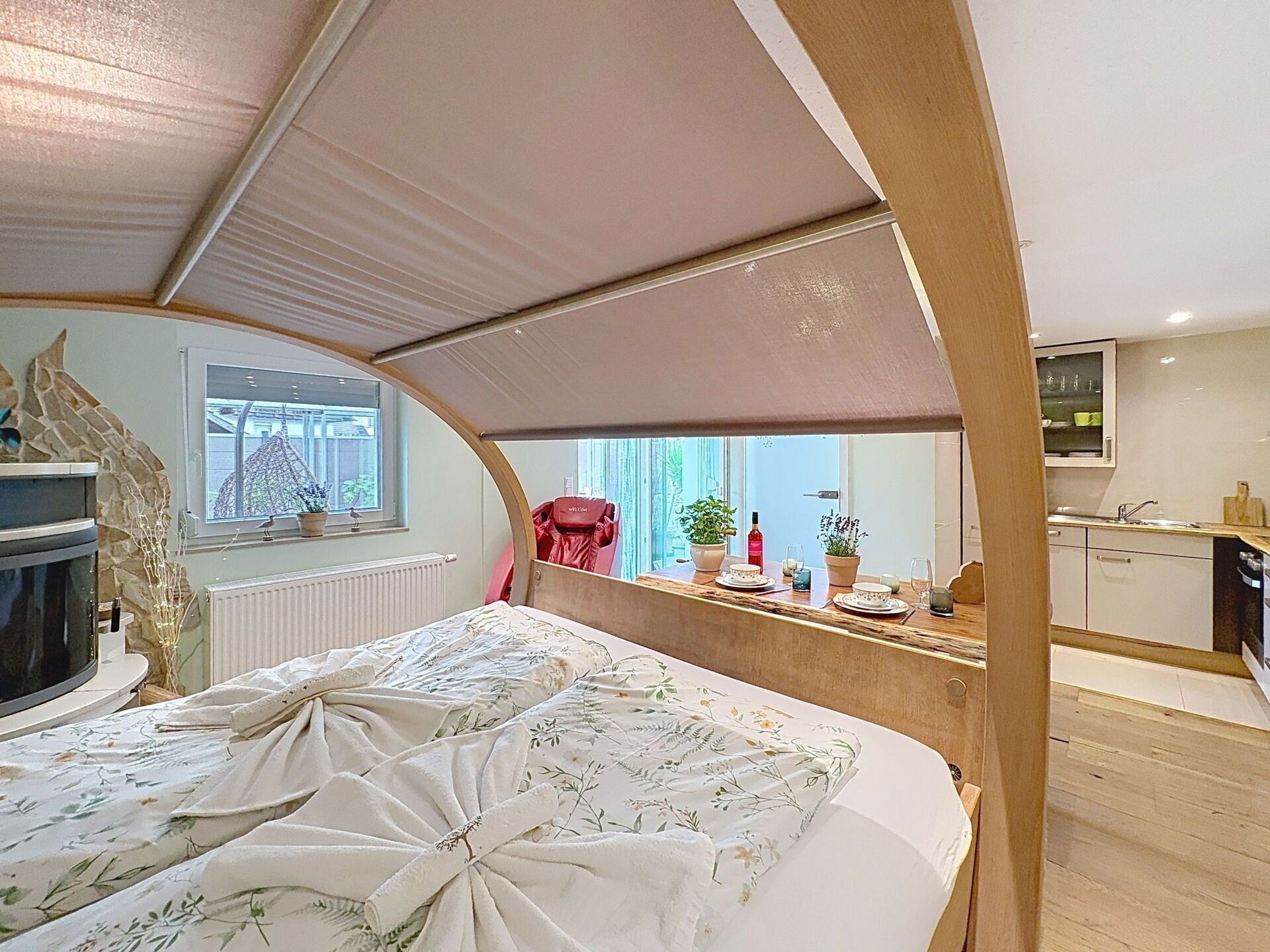 Une petite chambre comprenant un lit, une kitchenette et une fenêtre.