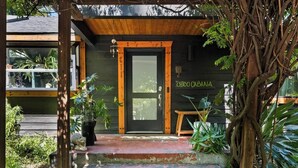 A wooden door with a sign reading 'CHICO CABANA' and a bench outside. - Lovely downtown Chico home (Chico)
