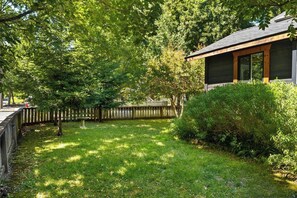 A residential property with a fenced backyard, a wooden deck, and a house with a dark exterior and large windows. - Lovely downtown Chico home (Chico)