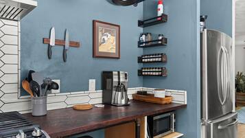 A kitchen with a coffee maker, a microwave, and a stainless steel refrigerator.