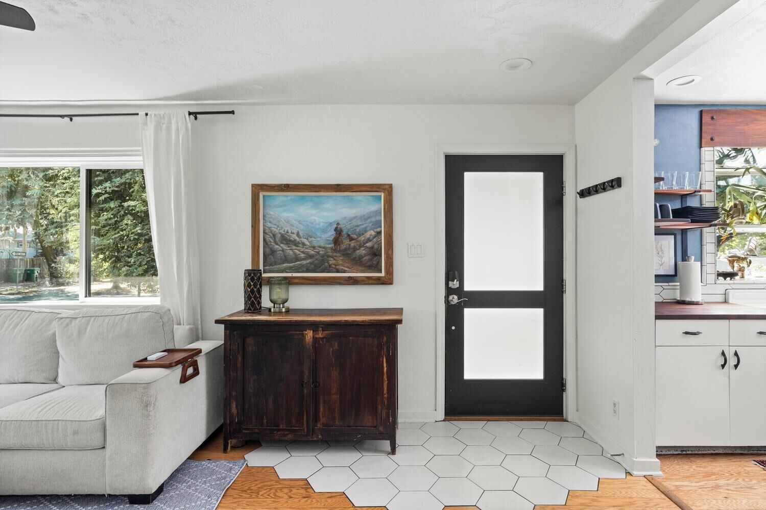 Een modern interieur met een bank, een kast, een deur en een raam.