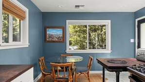 A dining area with a round table, four chairs, and a window with a view of trees. - Lovely downtown Chico home (Chico)