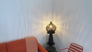 Una habitación con un sofá, una silla, una lámpara y un tapete estampado.