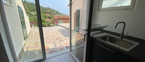 A modern kitchen with a built-in sink and a sliding glass door leading to an outdoor patio.