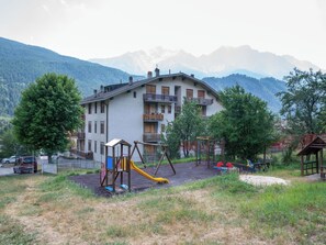 Un immeuble d’habitation doté d’un terrain de jeux, situé dans une région montagneuse.