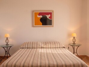 Ein Hotelzimmer mit einem Bett, zwei Nachttischen und einem Wandbild.