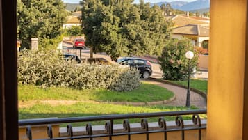 Une rue résidentielle bordée de voitures garées, avec une route sinueuse et de la verdure.