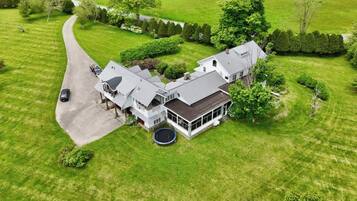 A large, two-story house with a driveway and a trampoline in the front yard.