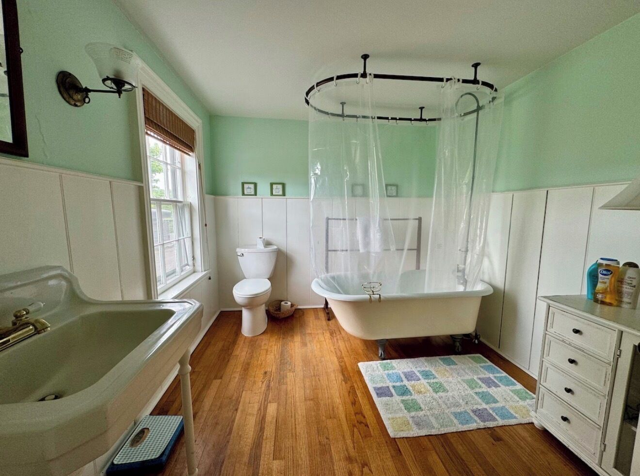 Une salle de bain avec une baignoire, des toilettes, un lavabo et une fenêtre.