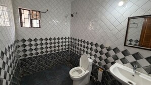 Un baño con inodoro, lavabo y una ventana con rejas.