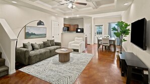 A spacious living area with a ceiling fan, a sofa, a coffee table, and a dining table with chairs. - SD2 • Spacious Family Townhome•3BR• Backyard• Fast Wi-Fi (Selma)