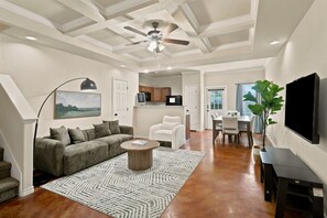 A spacious living area with a ceiling fan, a sofa, a coffee table, and a dining table with chairs. - SD2 • Spacious Family Townhome•3BR• Backyard• Fast Wi-Fi (Selma)