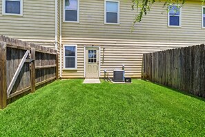 A residential backyard with a wooden fence, a door, and an air conditioning unit. - SD2 • Spacious Family Townhome•3BR• Backyard• Fast Wi-Fi (Selma)