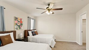 A hotel room with two beds, a ceiling fan, a painting, and a door. - SD2 • Spacious Family Townhome•3BR• Backyard• Fast Wi-Fi (Selma)