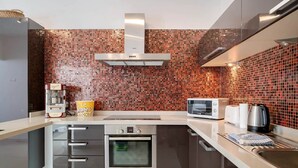 Een moderne keuken met een Bosch oven, magnetron, waterkoker en een popcornmachine.