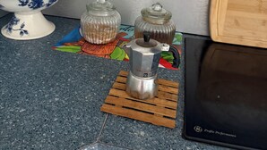 A kitchen counter with a coffee maker, two glass jars, a floral bowl, and a colorful placemat. - Studio apartment 7 minutes from the airport in Carolina (Carolina)