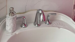 A bathroom with a white sink, two faucets, a soap dispenser, and a pink shower curtain. - Studio apartment 7 minutes from the airport in Carolina (Carolina)