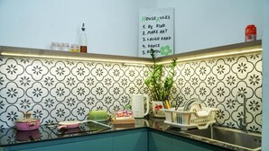 A kitchen with a decorative backsplash, a sink, and a list of house rules on the wall. - NHÀ TRONG NGÕ (Da Nang)