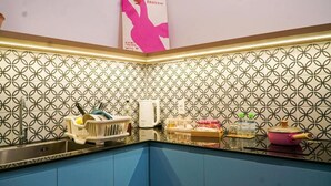 A kitchen with patterned backsplash, a sink, and various kitchen items. - NHÀ TRONG NGÕ (Da Nang)