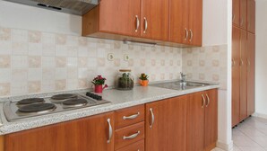 Una cocina con armarios de madera, extractor de acero inoxidable, encimera de granito y lavaplatos doble.