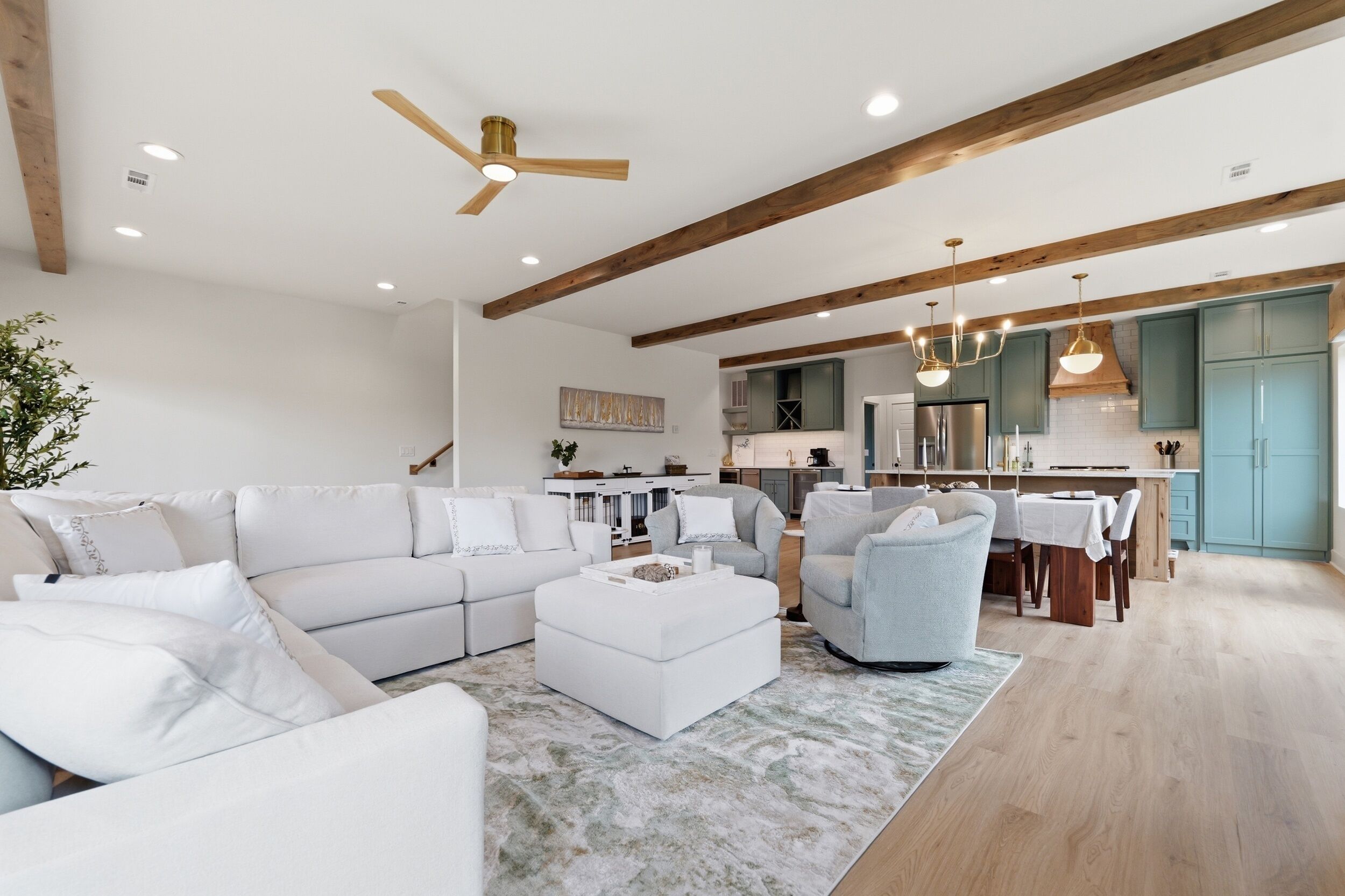 Un salon moderne avec un ensemble de canapés blancs, une table basse et un coin repas comprenant une table et des chaises.