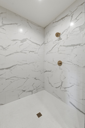 A bathroom with marble walls and a shower area. - Luxury Lakefront Escape on Beaver Lake - Sleeps the Whole Crew (Rogers)