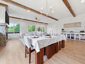 A spacious dining area with a long wooden table, white tablecloth, and candle holders. - Luxury Lakefront Escape on Beaver Lake - Sleeps the Whole Crew (Rogers)