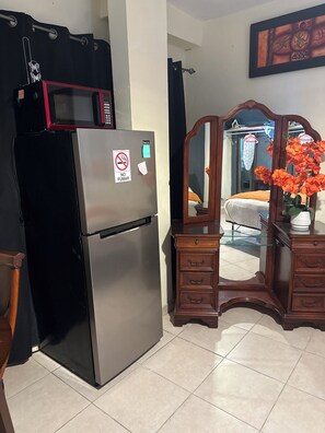 A kitchen with a stainless steel refrigerator, a wooden dresser with drawers, and a mirror. - 7 minutes from the airport (Carolina)