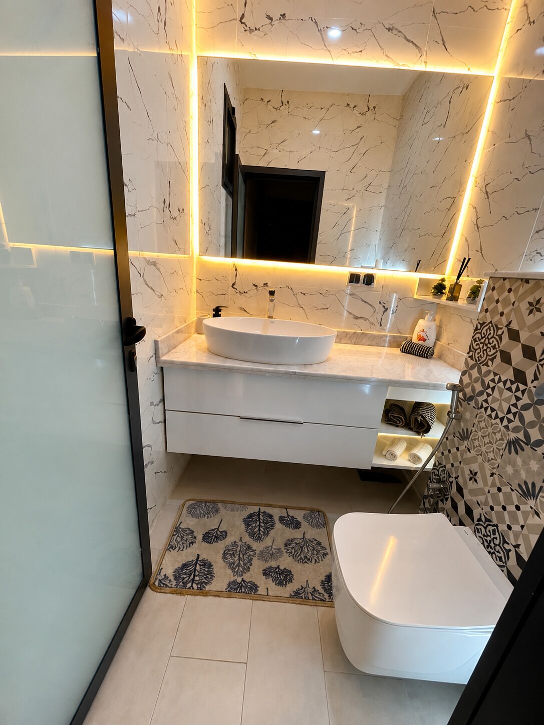 Une salle de bain moderne avec un lavabo blanc, un miroir et des toilettes.