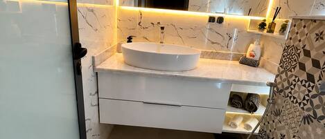 Une salle de bain moderne avec un lavabo blanc, un miroir et des toilettes.