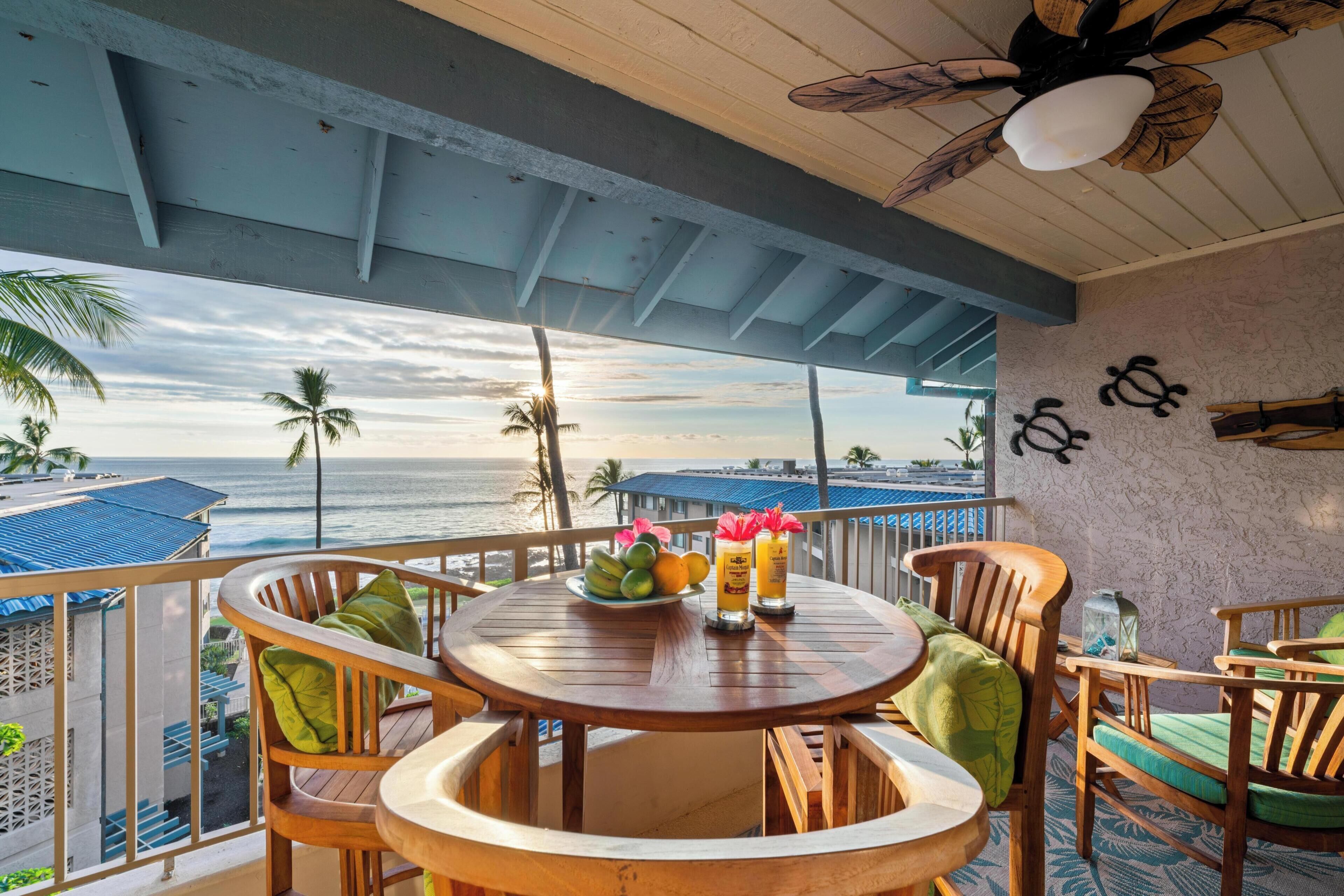 A wooden deck with a round table, chairs, and a view of the ocean.