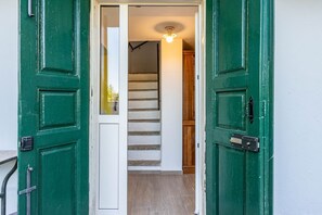 A green door leading to a staircase with a light fixture above. - Cà dal Maestar, Nature, Hiking, and Relaxation - Valstrona - By Guestaly (Valstrona)