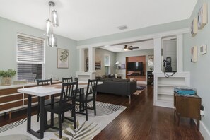 A modern living room with a dining area, a fireplace, and a television. - Boho Bliss Downtown Retreat - Tampa Heights -Tampa (Tampa)