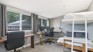 A bedroom with a bunk bed, a desk with two computers, a chair, and a window with curtains. - Boho Bliss Downtown Retreat - Tampa Heights -Tampa (Tampa)