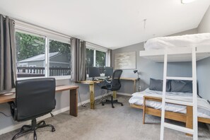 A bedroom with a bunk bed, a desk with two computers, a chair, and a window with curtains. - Boho Bliss Downtown Retreat - Tampa Heights -Tampa (Tampa)