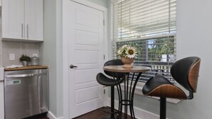 A kitchen with a dishwasher, a white door, and a window with blinds. - Boho Bliss Downtown Retreat - Tampa Heights -Tampa (Tampa)