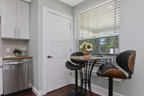 A kitchen with a dishwasher, a white door, and a window with blinds. - Boho Bliss Downtown Retreat - Tampa Heights -Tampa (Tampa)