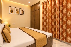 A hotel room with a bed, a wardrobe, a curtain, and wall art.
