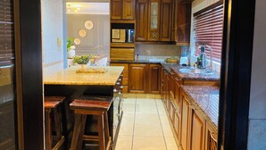 A kitchen with wooden cabinets, a granite countertop, and a built-in oven.