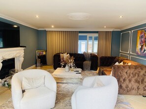 Un salon avec une cheminée, deux canapés, une table basse et un téléviseur.