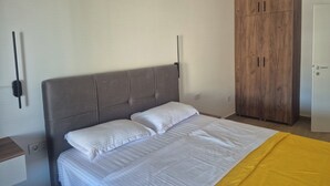 A bedroom with a bed, a wardrobe, and a bedside table. - Sky 47 apartment - modern comfort with free parking (Ohrid)