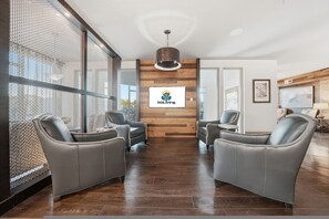 A modern interior with leather sofas, a wooden accent wall, and a logo for 'SOL Living'. - Modern 2BR w/ Pool + Pet-Friendly | Unit #24 (Tampa)