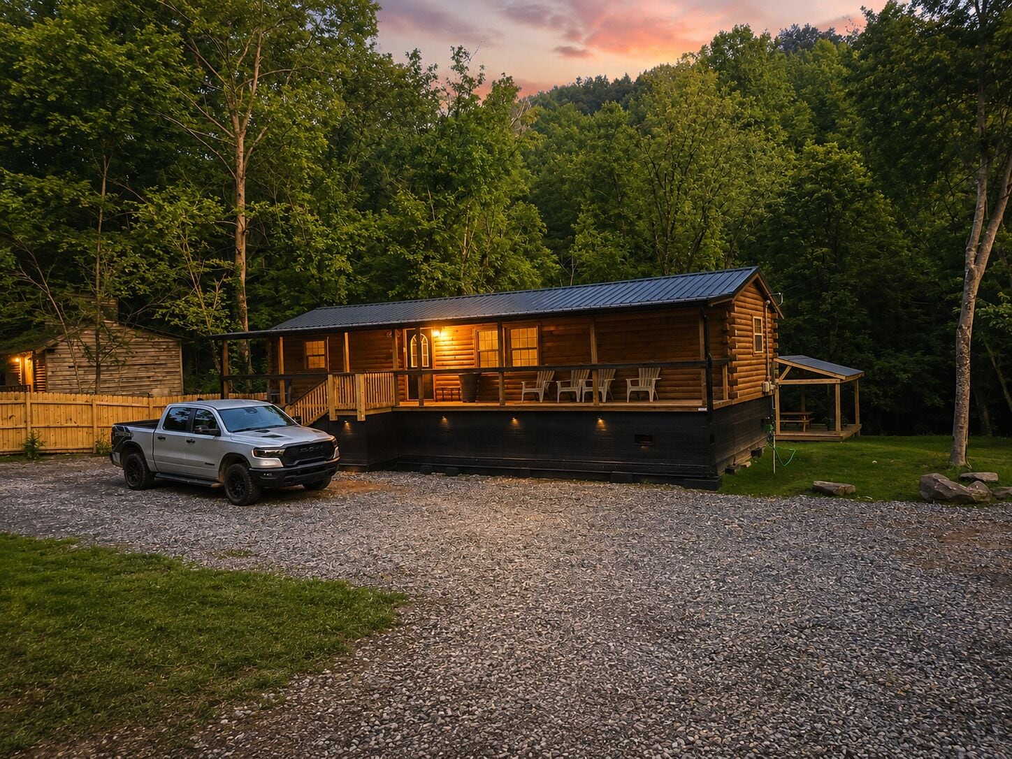 A cabin with a gravel driveway, wooden deck, and a covered outdoor seating area.