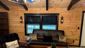 A cozy room with a leather sofa, a wooden chair, and a small table with a plant.