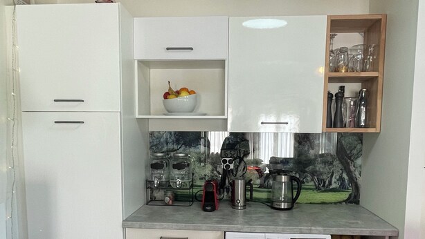 A compact kitchen with a washing machine, a coffee maker, and a fruit bowl on the counter. - Apartment in a renovated farmhouse: 2 bedrooms · 40 m² terrace, garden, parking · 12 km from Toulouse (Lapeyrouse-Fossat)